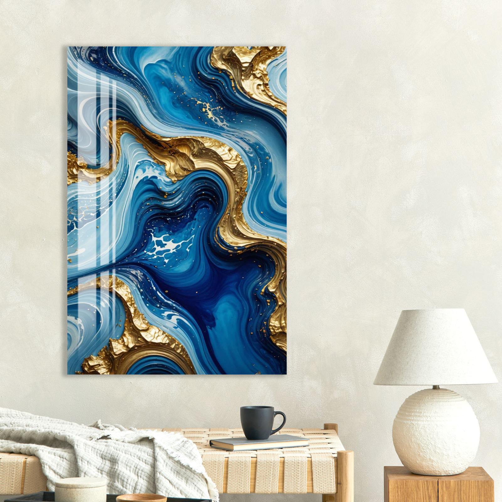 a large abstract painting with swirling blue and gold colors, hanging on a wall above a wooden table with a lamp and a book.