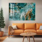 a modern living room with a large abstract painting hanging on the wall above a cozy orange sofa. The sofa is positioned in front of a coffee table, which has a few glasses on it. The room also includes a potted plant and a wooden floor, creating a warm and inviting atmosphere.