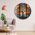 a living room with a large circular wall art depicting a colorful stained glass tree with a sunset in the background. The room has a pink pendant light, a gray sofa, and a wooden coffee table.