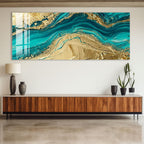 a large, abstract painting with turquoise and gold colors, displayed on a wall above a wooden cabinet.