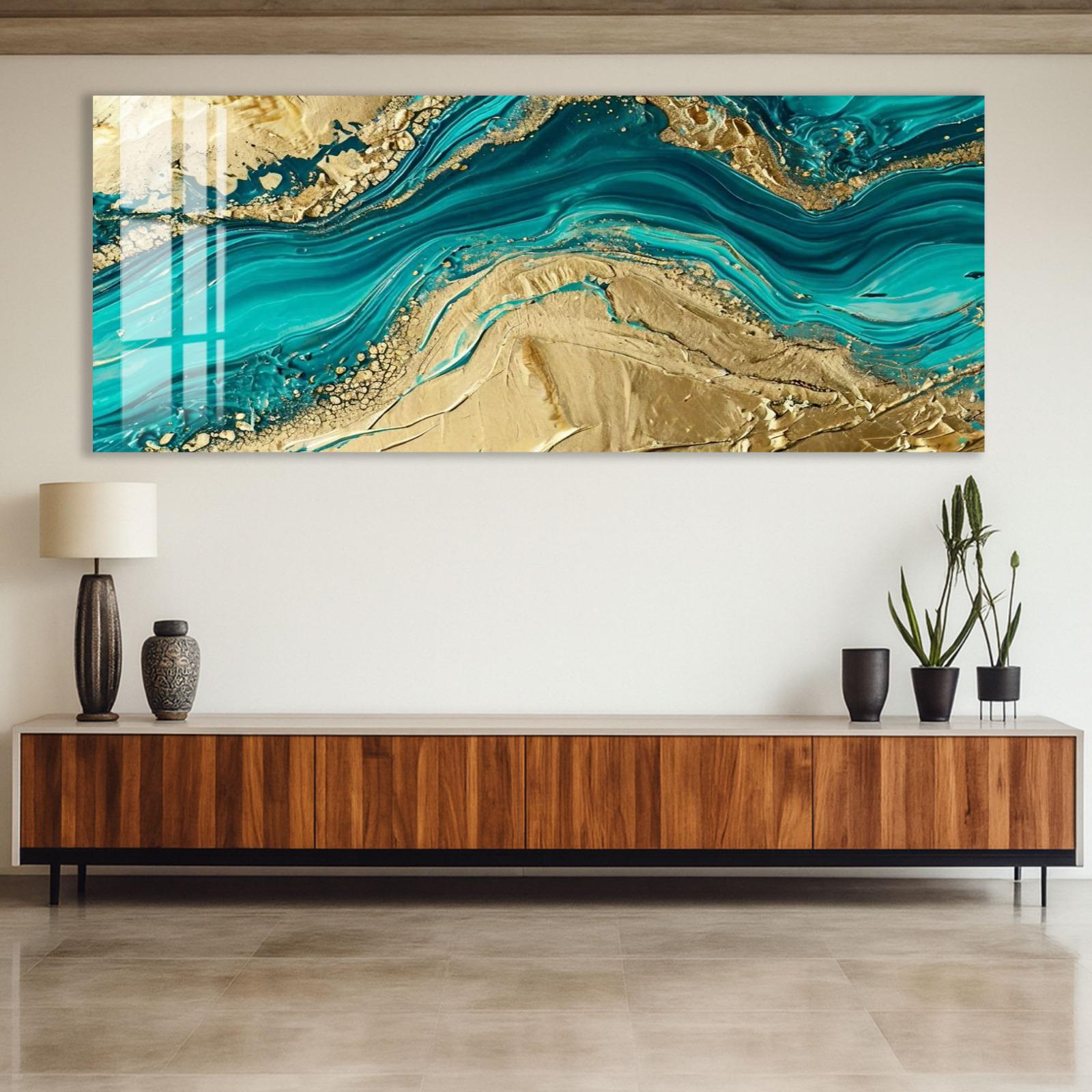 a large, abstract painting with turquoise and gold colors, displayed on a wall above a wooden cabinet.