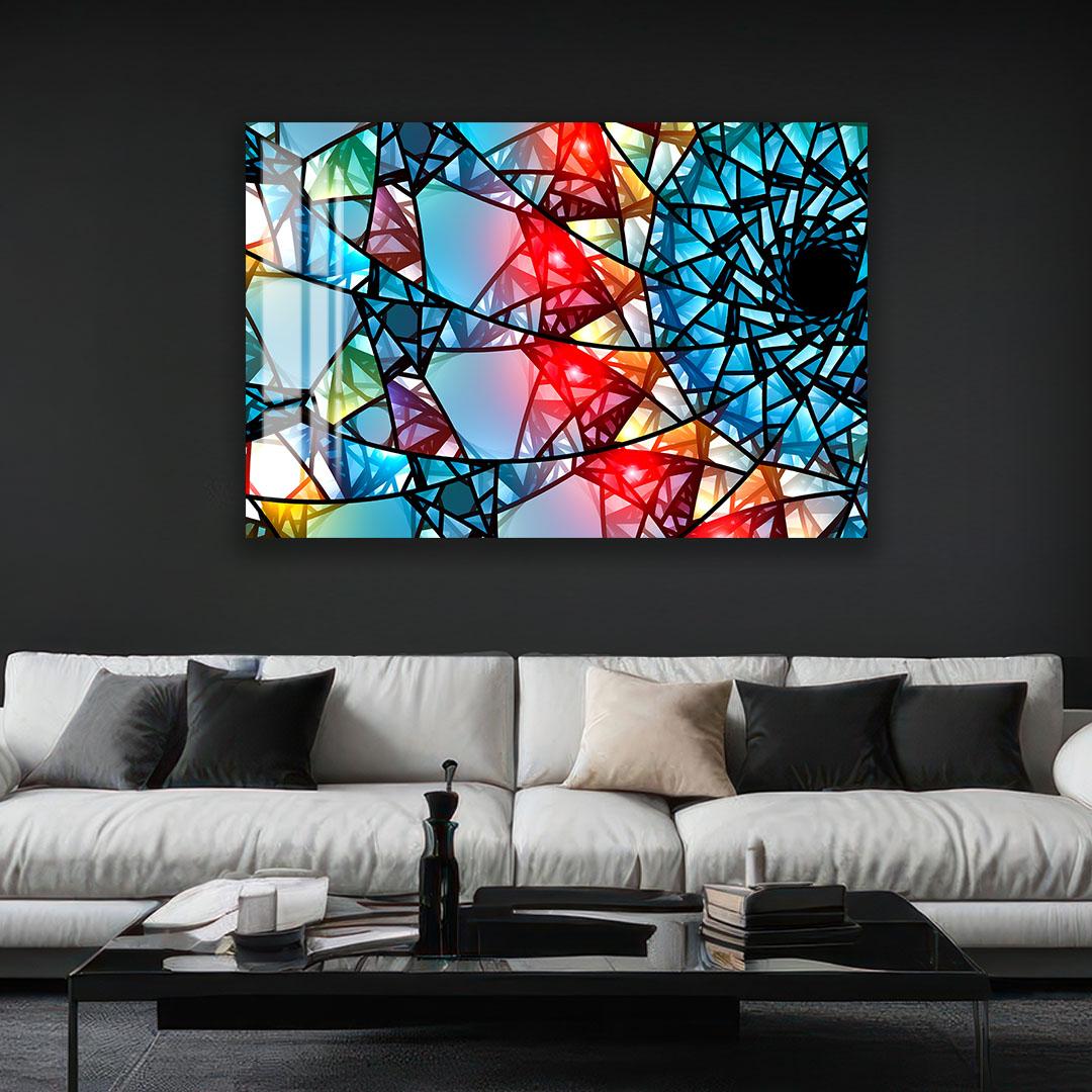a modern living room with a large abstract painting hanging on the wall above a white sofa. The painting has a vibrant, colorful design with various geometric shapes and patterns.