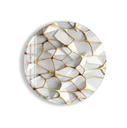 a white oval-shaped object with a geometric pattern of overlapping white and gold shapes.