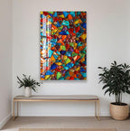 a vibrant, colorful abstract painting hanging on a white wall above a wooden bench and a potted plant.