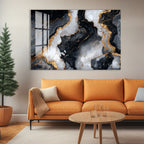 a modern living room with a large abstract painting of black and white marble on the wall above a cozy orange sofa. The sofa is positioned in front of a wooden coffee table, which has a glass top. The room also includes a potted plant and a small tree, adding a touch of greenery to the space.
