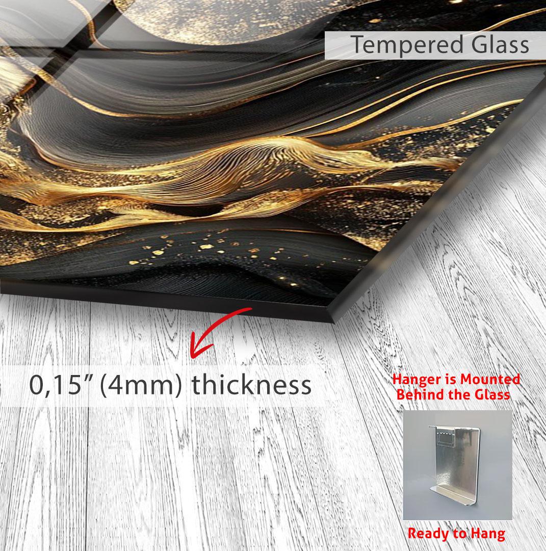 The image is a close-up of a glass surface with a gold and black abstract design, and it is mounted on a wall.