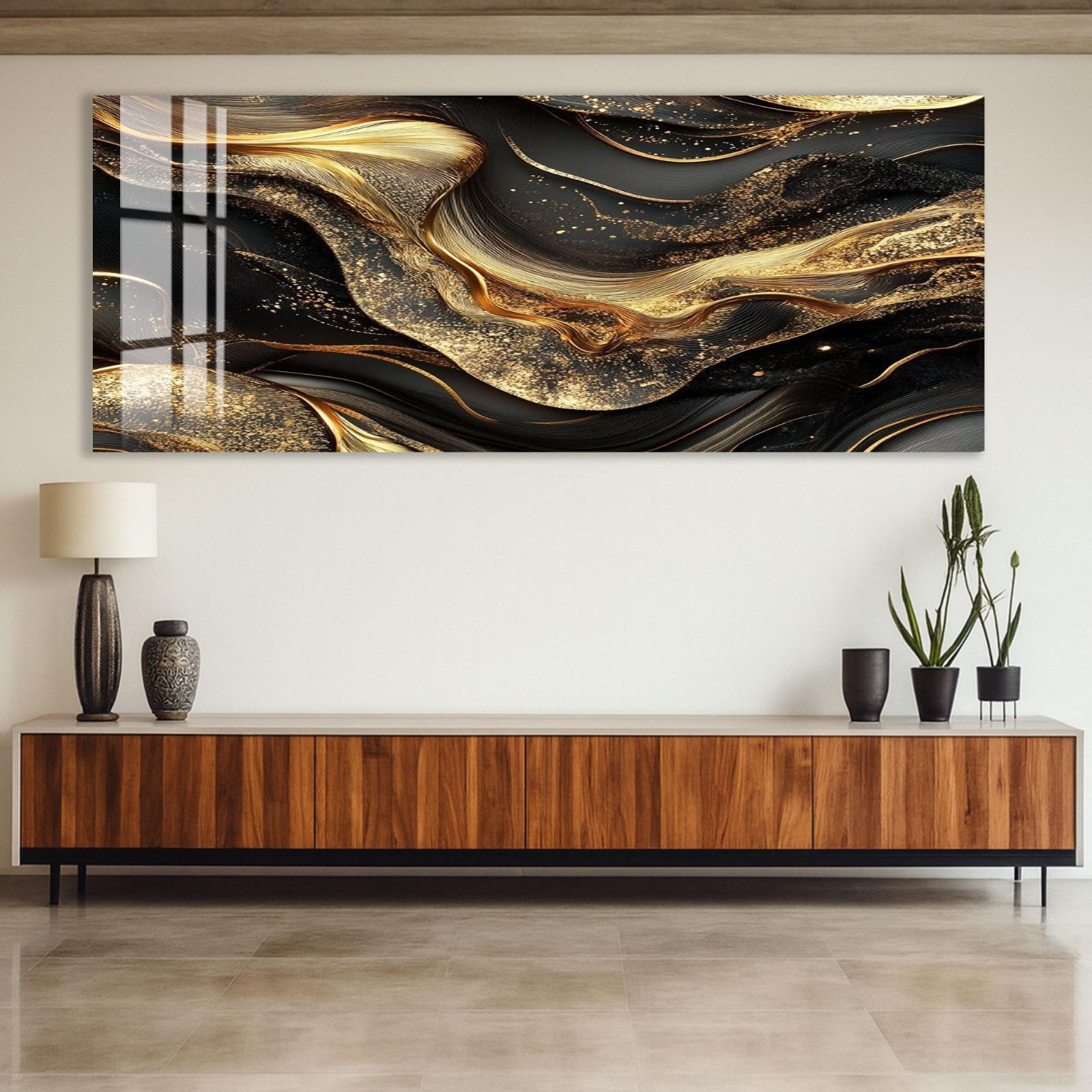 a large abstract painting with swirling black and gold patterns hanging on a wall above a wooden cabinet.