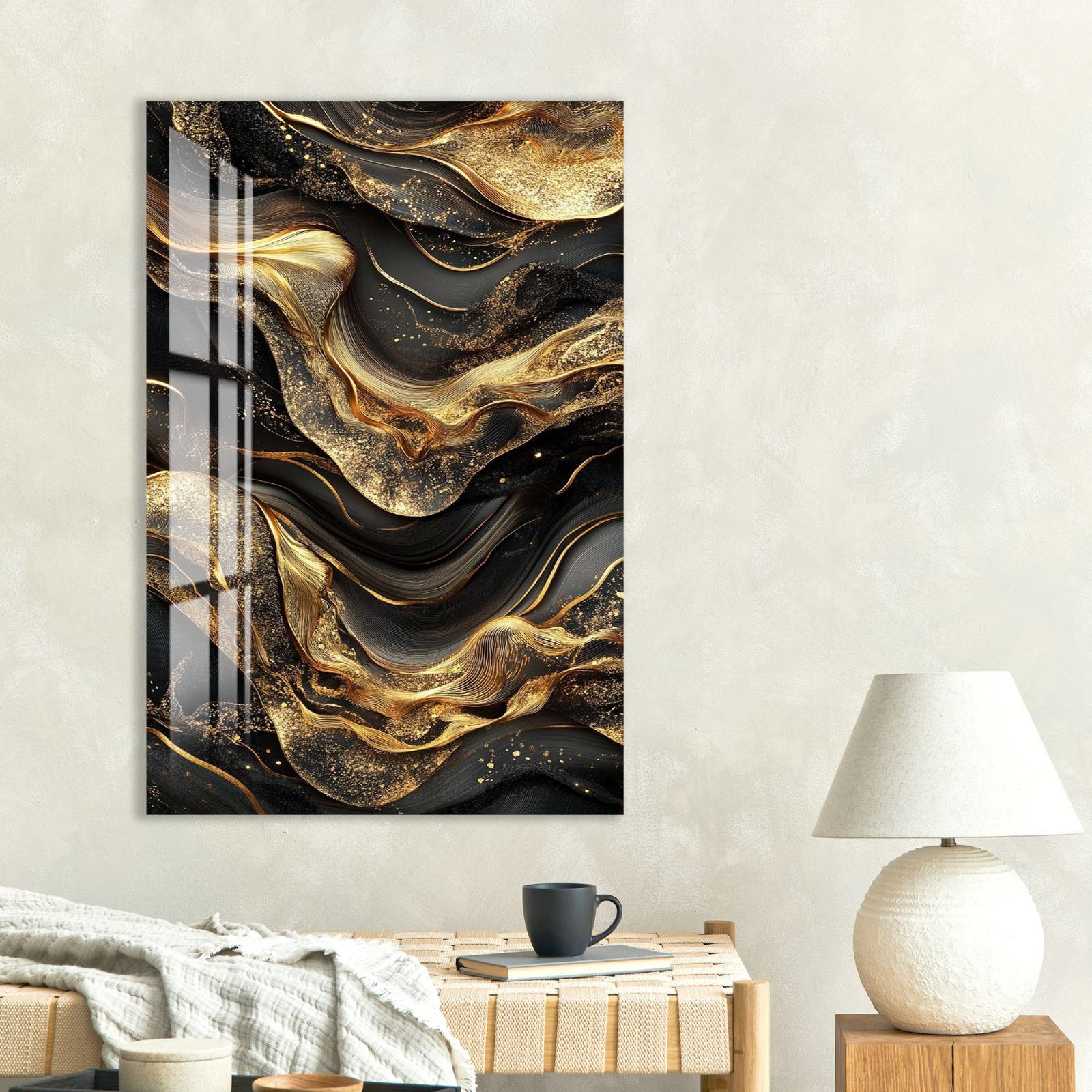 a large abstract painting with swirling black and gold patterns hanging on a wall above a wooden table with a lamp and a book.
