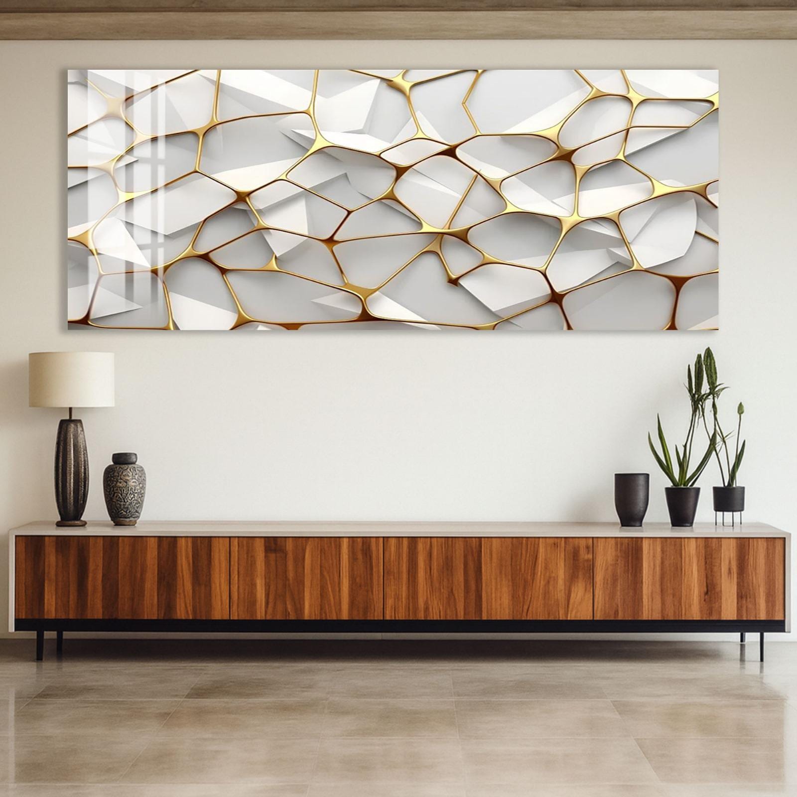 a modern living room with a large abstract painting hanging on the wall above a wooden cabinet. The painting has a geometric design with a mix of white and gold colors. The cabinet has a dark wood finish and is topped with a light wood base. On the cabinet, there are two black vases and two potted plants, adding a touch of greenery to the space.