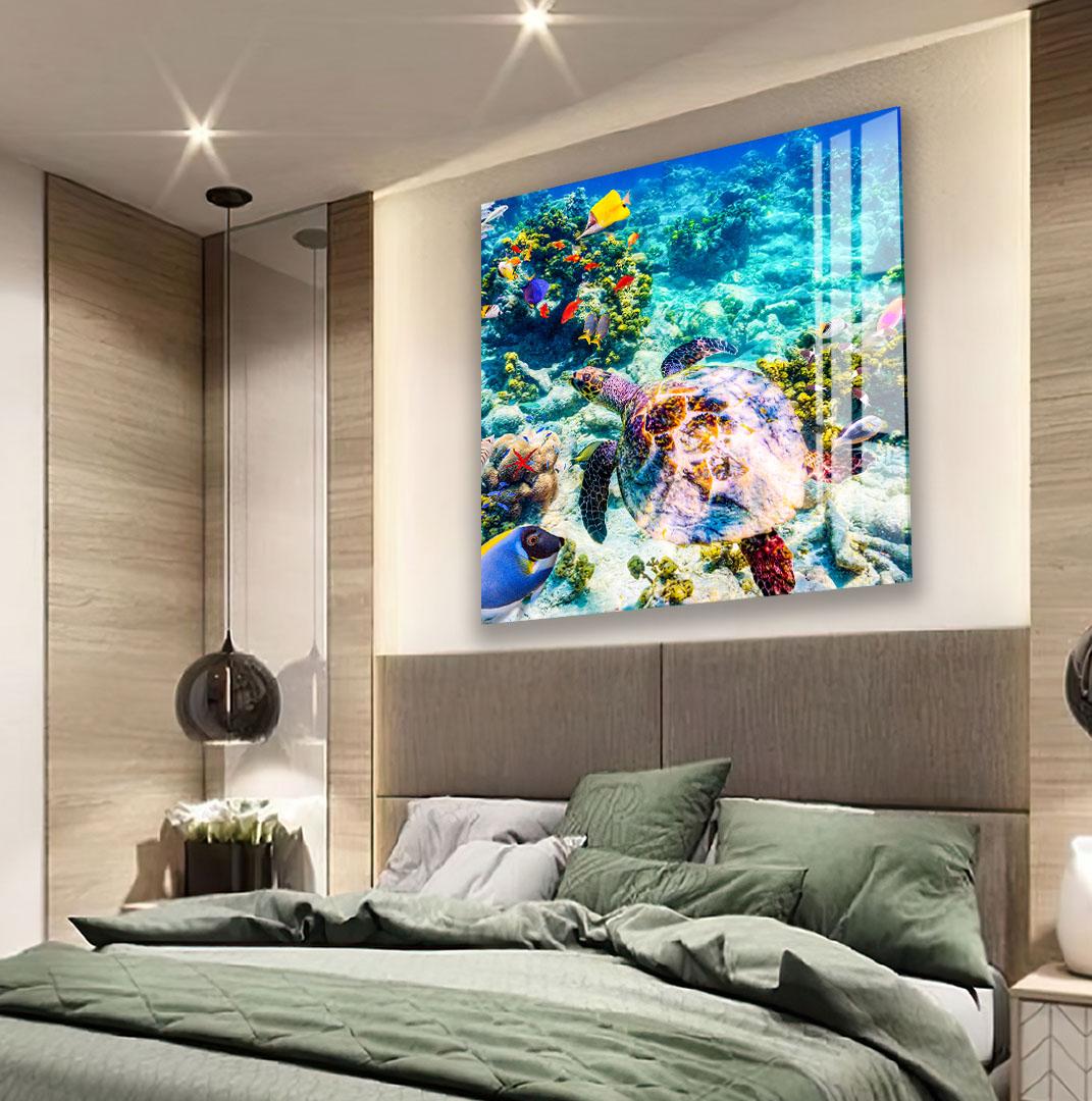 a large, colorful painting of a vibrant underwater scene with a variety of marine life, including a large sea turtle, fish, and coral. The painting is displayed on the wall above a bed with green bedding, creating a serene and relaxing atmosphere in the bedroom.