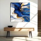 a modern art piece with a striking abstract design of blue and gold swirls on a white background, hanging on a wall above a wooden console table.