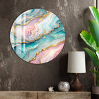 a large, round, colorful abstract painting hanging on a wall, with a lamp and a plant to the right of the painting.