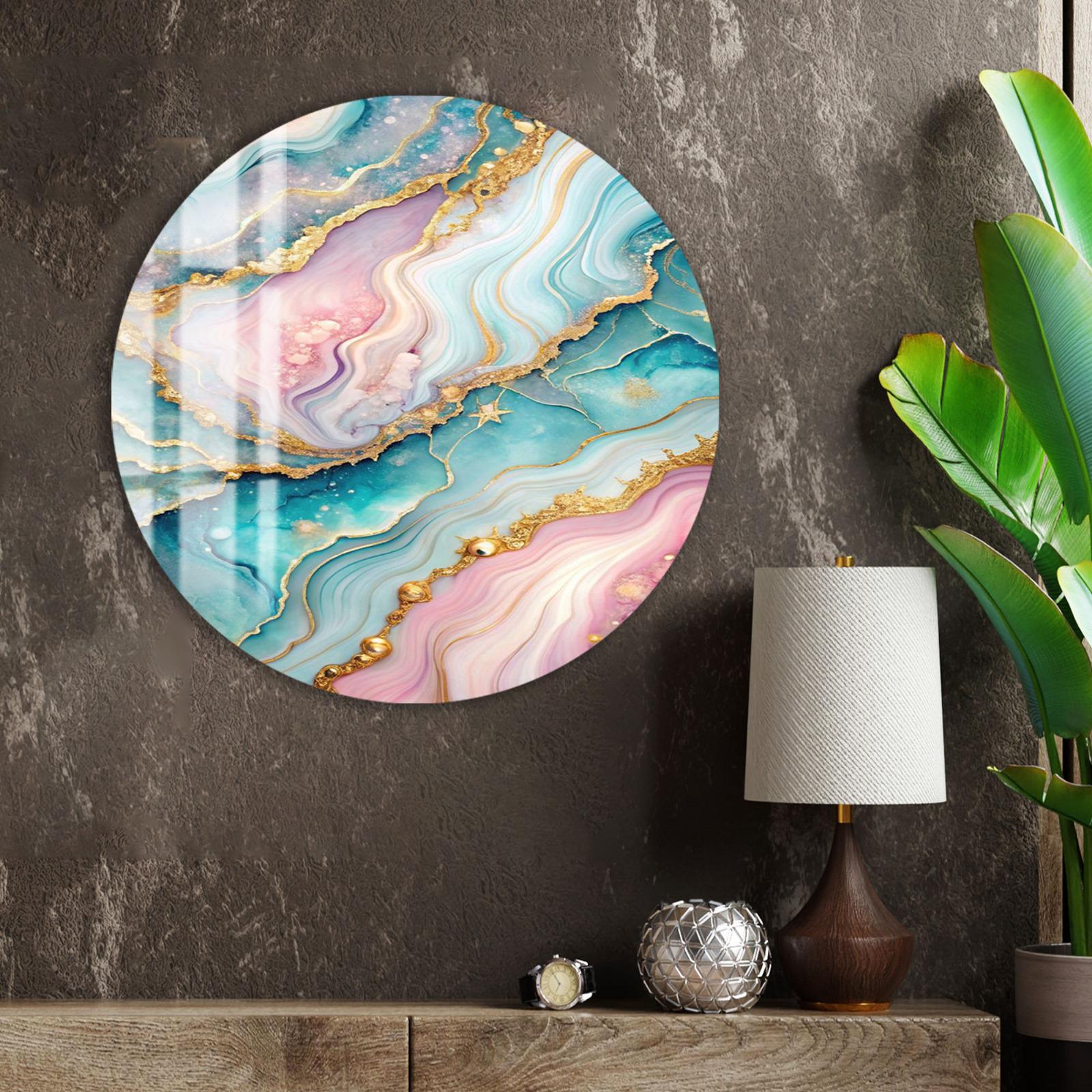 a large, round, colorful abstract painting hanging on a wall, with a lamp and a plant to the right of the painting.