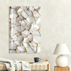 a modern living room with a large abstract wall art piece featuring a geometric pattern in white and gold colors. The room also includes a wooden coffee table with a black mug and a white lamp, creating a cozy and stylish atmosphere.