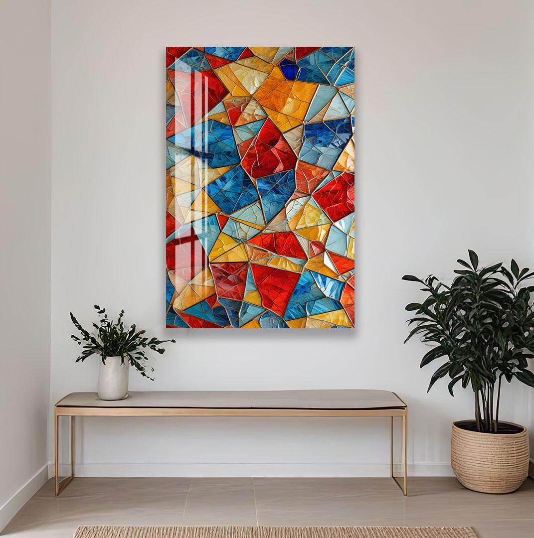 a vibrant, colorful abstract painting hanging on a white wall above a wooden bench and a potted plant.