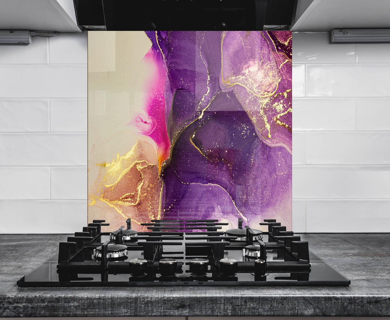 a modern kitchen with a large, colorful abstract painting on the wall behind a gas stove.