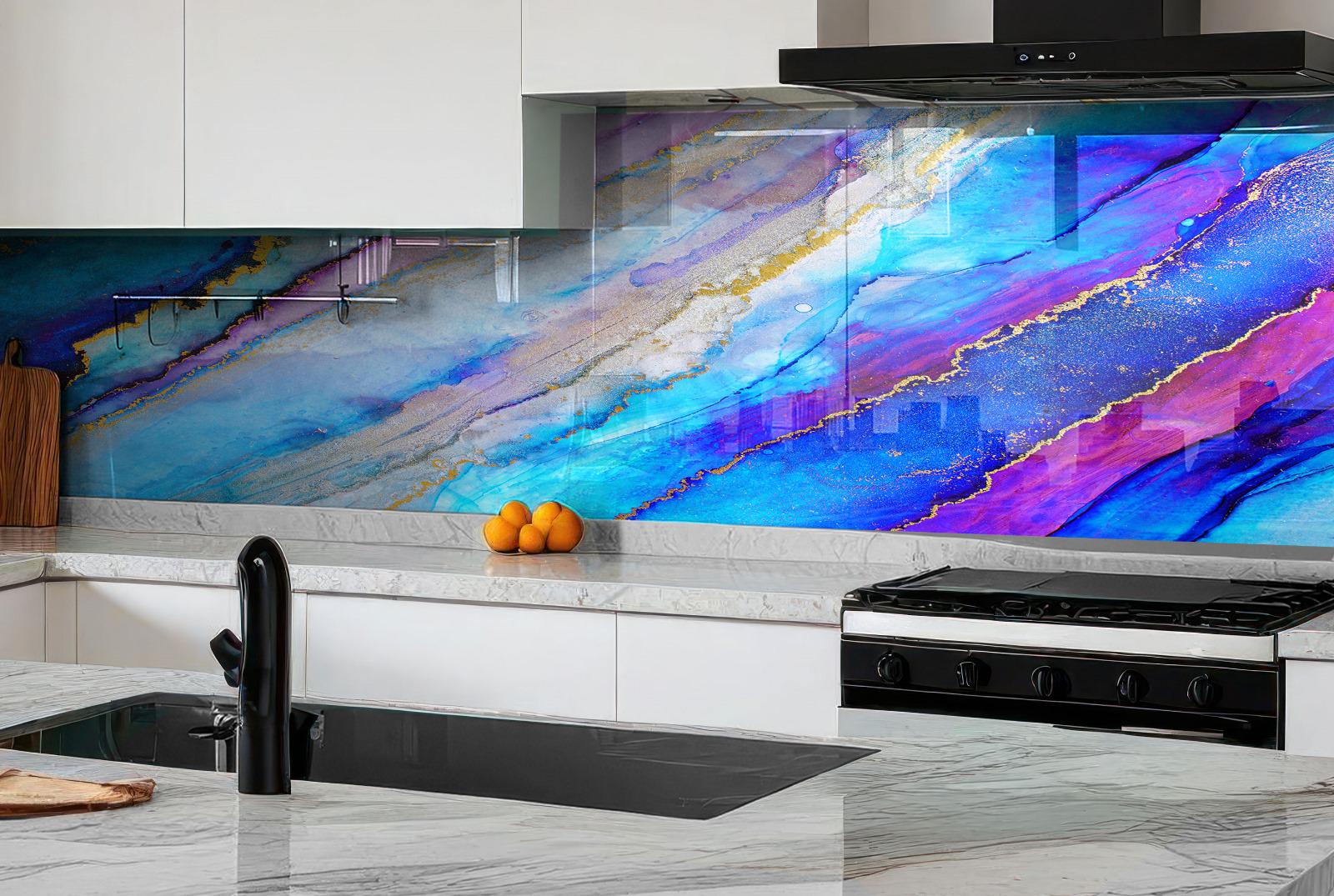 a modern kitchen with a striking backsplash that showcases a vibrant abstract design in shades of blue, purple, and pink. The kitchen is equipped with a gas range, a sink, and a wooden cutting board. On the countertop, there are a few oranges and a black faucet.