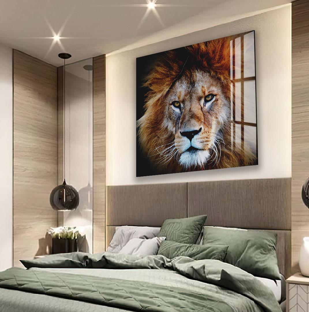a large, high-quality photograph of a lion's face displayed on the wall above a bed with a green comforter.