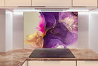 a kitchen counter with a marble top and a large abstract painting in shades of purple and gold behind it.