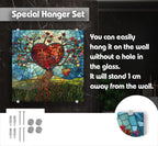 The image is a special hanger set that includes a heart-shaped mosaic artwork and a glass panel. The heart-shaped mosaic is a colorful, abstract design with a tree-like structure and various shapes and colors. The glass panel is a rectangular, transparent piece that can be hung on the wall without a hole in it. The hanger set is designed to be easily installed and securely attached to the wall, allowing the heart-shaped mosaic and glass panel to be displayed prominently.