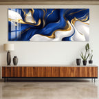 a large abstract painting with swirling blue and gold colors, hanging on a wall above a wooden entertainment center.