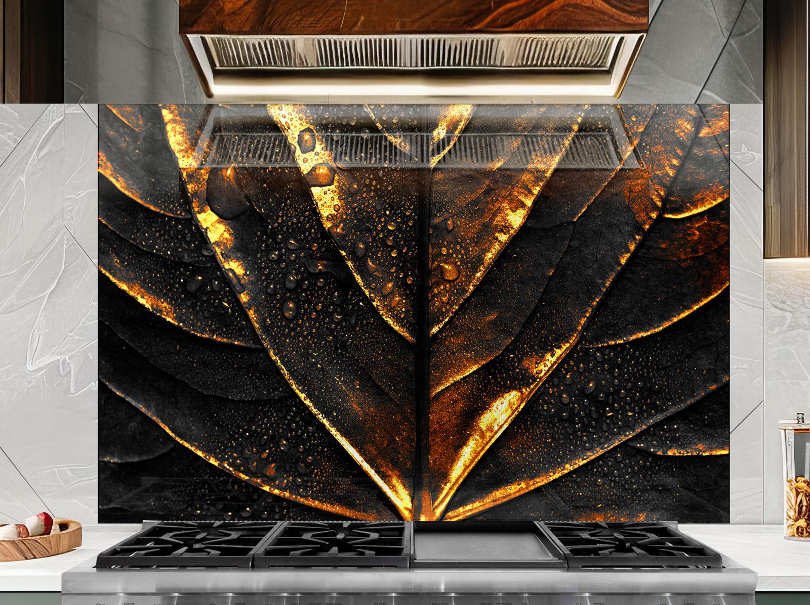 a striking black and gold leaf-like pattern on a wall, with a modern kitchen stove and countertop in the foreground.