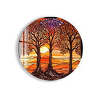 A circular glass plate with a vibrant stained glass-style illustration depicting a sunset scene with three trees in the foreground.