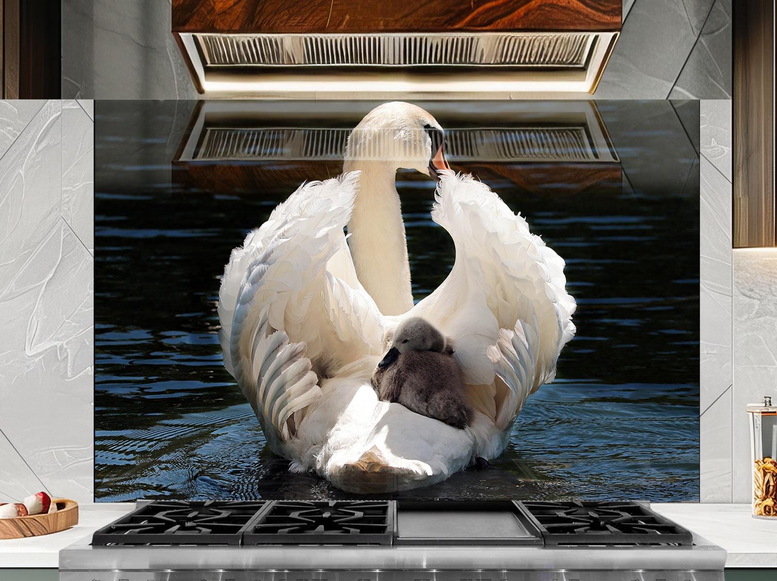 A large white swan with its wings spread, resting on a body of water, with a smaller swan nestled on its back.