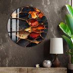 a large circular wall art piece with a striking abstract design of black, orange, and red colors, creating a vibrant and eye-catching visual effect. The art piece is mounted on a textured gray wall, and the surrounding area includes a lamp, a plant, and a small decorative item, creating a cozy and stylish atmosphere.