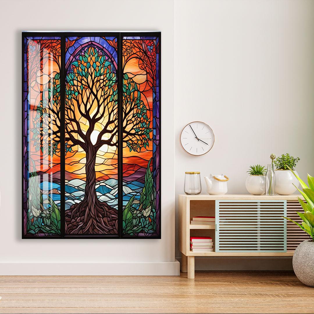 a large stained glass window with a vibrant tree design, hanging on a wall next to a wooden cabinet with a clock and some decorative items.