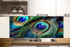 a kitchen with a large, colorful backsplash that showcases the intricate details of peacock feathers. The backsplash is a striking contrast of blue, green, and orange hues, creating a visually captivating display. The kitchen itself has white cabinets and a stainless steel sink, providing a clean and modern aesthetic.