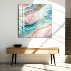 a vibrant abstract painting with swirling patterns of blue, pink, and gold colors, hanging on a white wall above a wooden console table.