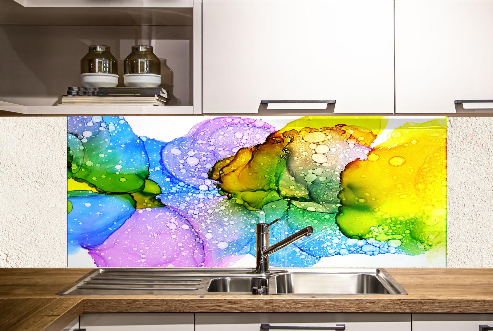 a kitchen with a colorful backsplash behind the sink. The backsplash displays a vibrant abstract pattern in various colors, including shades of blue, green, yellow, and purple. The kitchen has white cabinets and a stainless steel sink, creating a clean and modern aesthetic.