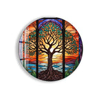 A stained glass artwork depicting a tree with intricate patterns and designs, set against a vibrant sunset landscape.