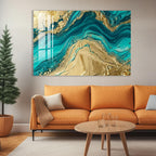 a modern living room with a large abstract painting hanging on the wall above a cozy orange sofa. The painting has a vibrant mix of blue and gold colors, creating a striking contrast against the neutral tones of the room. In front of the sofa, there is a wooden coffee table with a glass top, and a potted plant is placed on the floor next to the sofa.