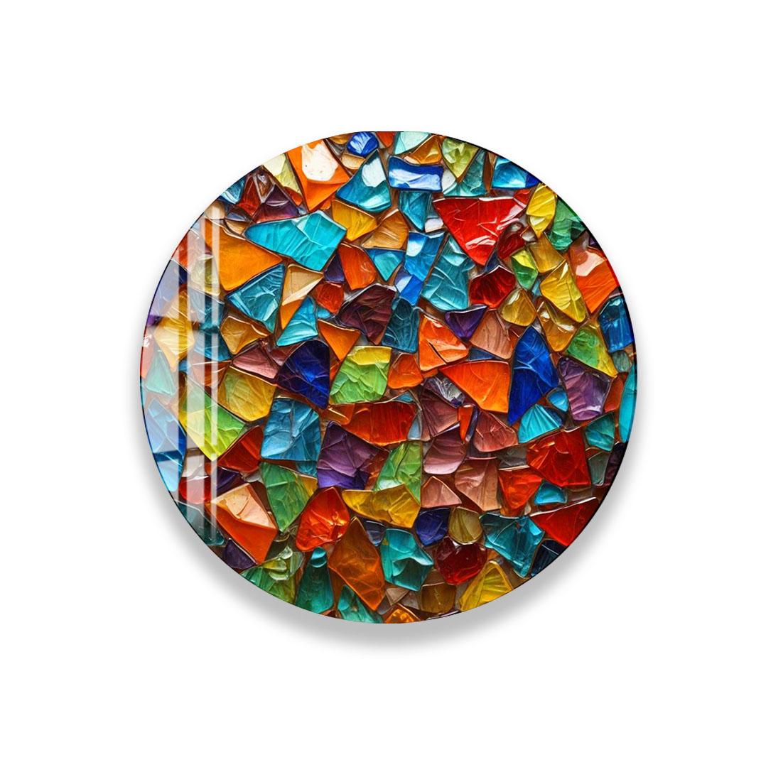 The image is a vibrant and colorful mosaic composed of numerous small, multicolored glass pieces arranged in a circular pattern.