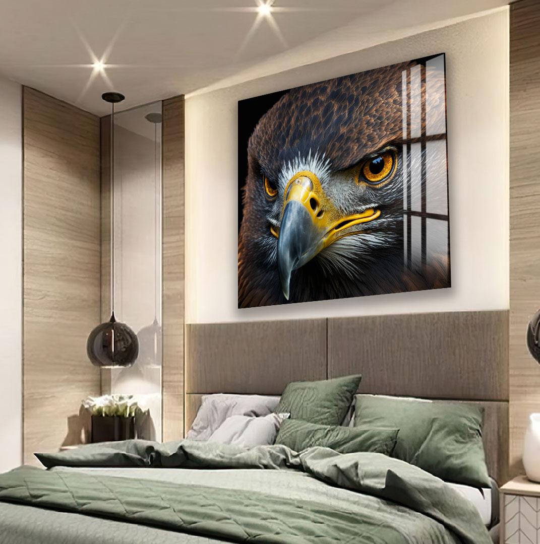 a large, close-up of a bird's face, likely an eagle, with its sharp beak and piercing eyes prominently displayed. The bird's head is turned to the side, giving a clear view of its features. The image is set against a backdrop of a wooden wall, which complements the overall aesthetic of the room.
