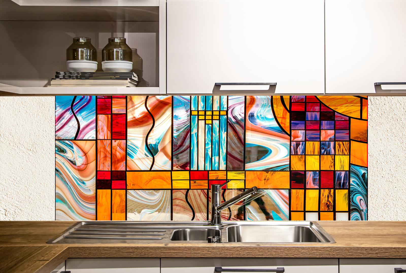 a modern kitchen with a vibrant, colorful backsplash made of stained glass. The backsplash showcases abstract geometric patterns in various colors, including shades of orange, blue, yellow, and red. The kitchen has white cabinets and a stainless steel sink, creating a clean and contemporary look.
