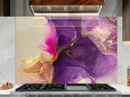 a kitchen counter with a large, colorful abstract painting or mural behind it. The painting has a purple and gold color scheme, with swirling patterns and textures that create a visually striking and artistic display.